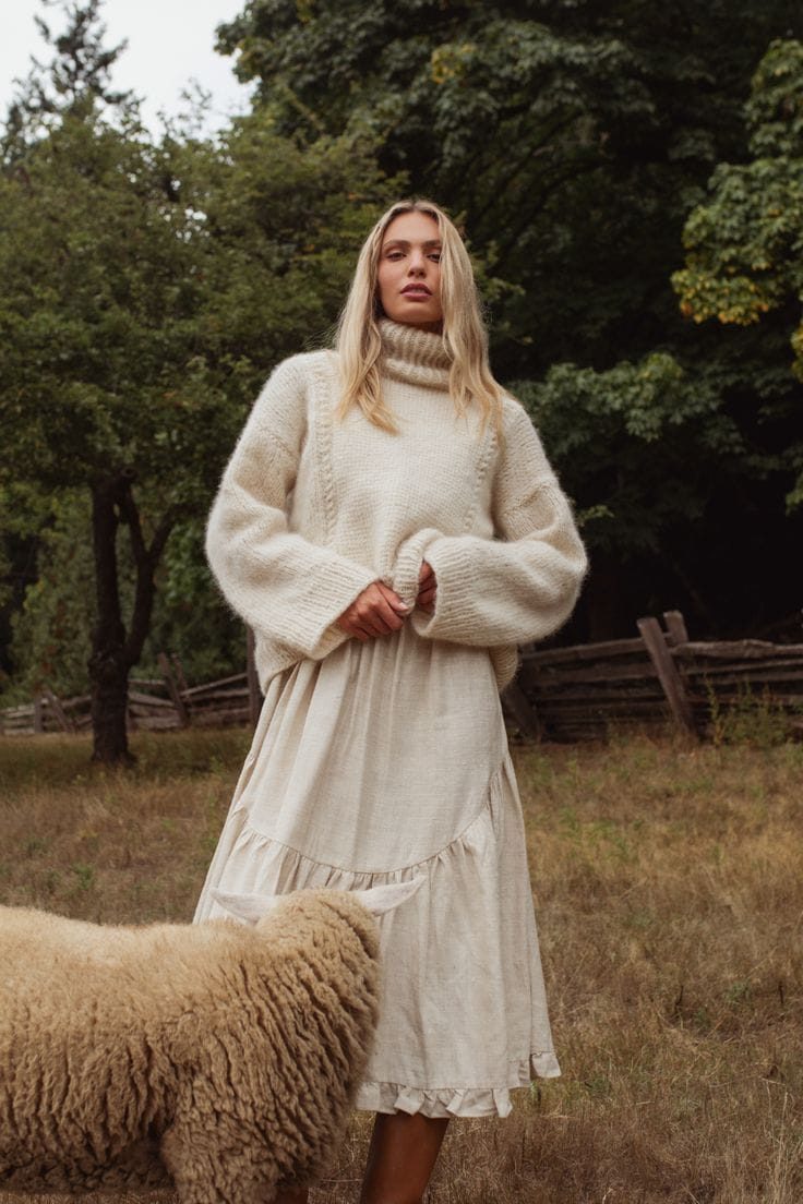 Model wearing Arega's hand-knit Cloud Sweater outdoors